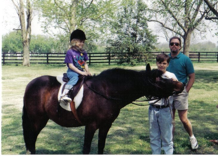 Erin’s dad and a family friend assist her during a pony ride when she’s 3 years old.