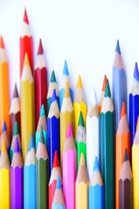 A vibrant, close-up collection of various colored pencils standing upright against a white background.