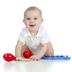 Funny baby  with musical toys. Isolated on white background