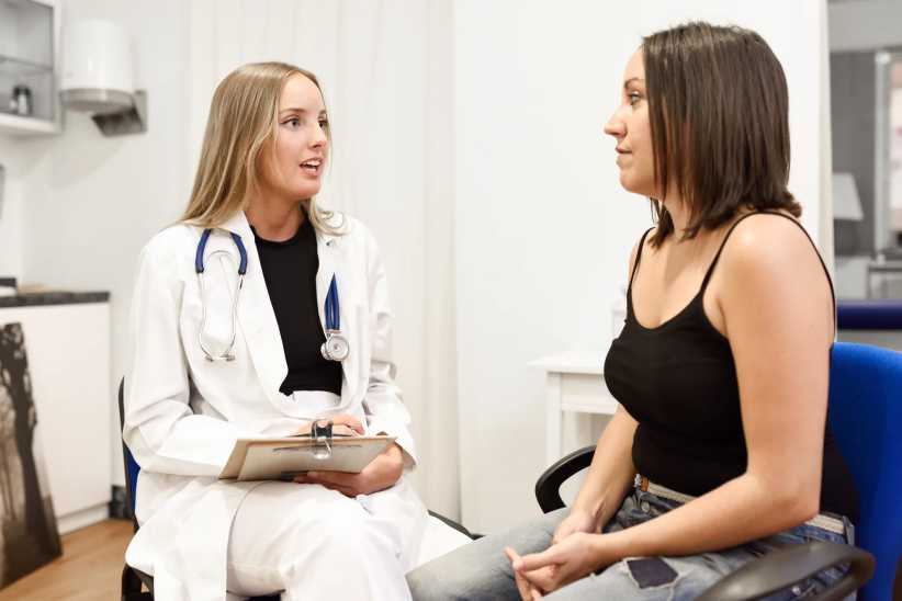 Female doctor explaining diagnosis to her patient. Brunette woman having consultation with blonde girl in medical office., menopause