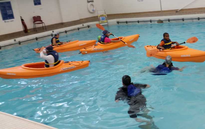 People participating in indoor kayaking at Gertrude Ederle Recreation Center