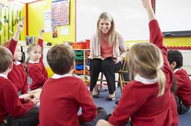 Teacher Reading Story To Elementary School Pupils