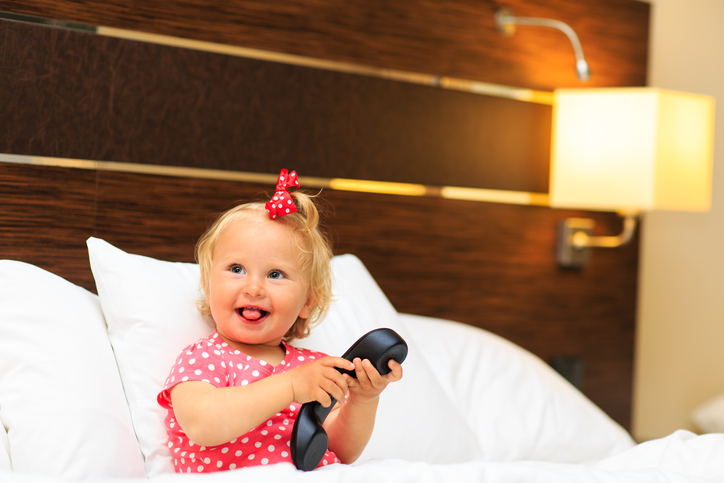 cute little girl taking on the phone in hotel room