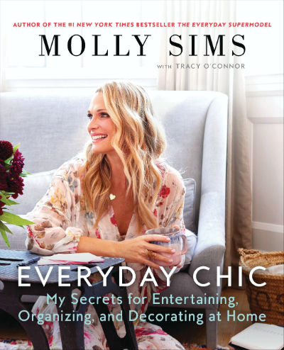 Molly Sims smiles while holding a mug on the cover of her book about home entertaining and decorating.