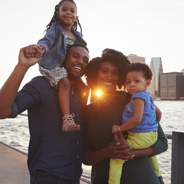 Young family with daughters standing on quayside