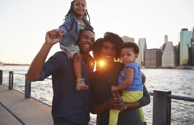 Young family with daughters standing on quayside