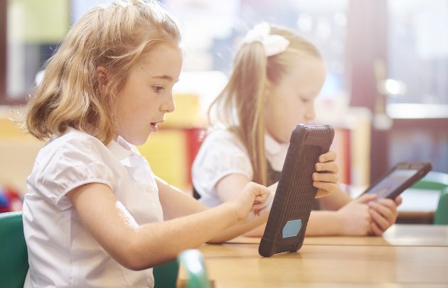 two girls using tablets