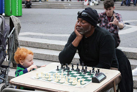 man and boy playing chess