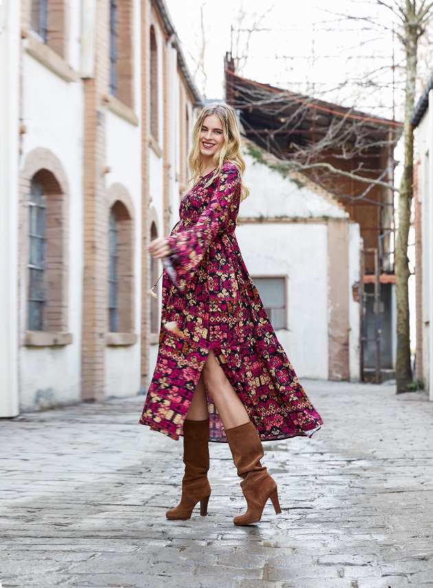 pregnant model in boho chic magenta dress and brown slouchy boots on a cobbletone street