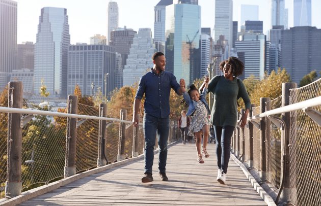 Young african-american parents with daughter taking a walk on footbridge on the highline in new york city
