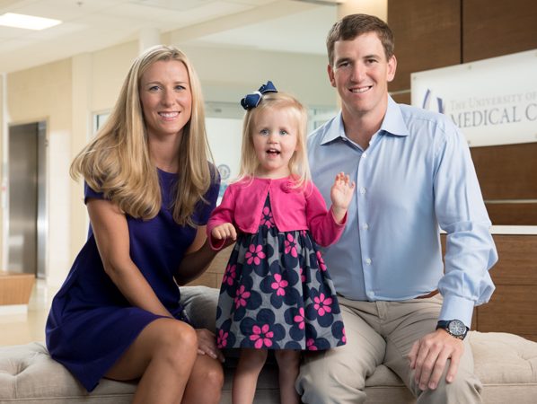 eli manning with wife and daughter in living room