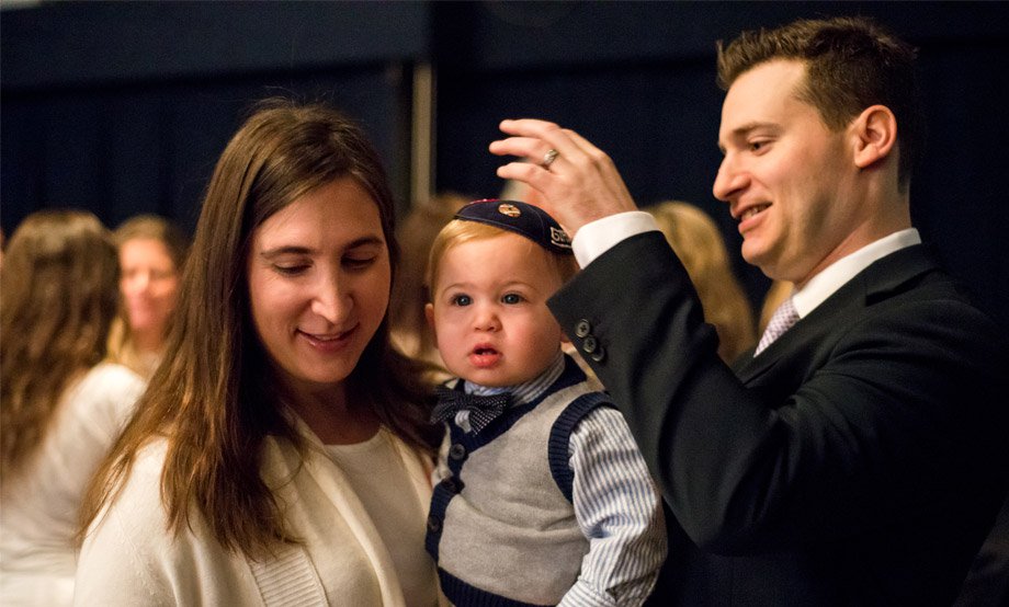 husband and wife with infant son wearing yarmulke