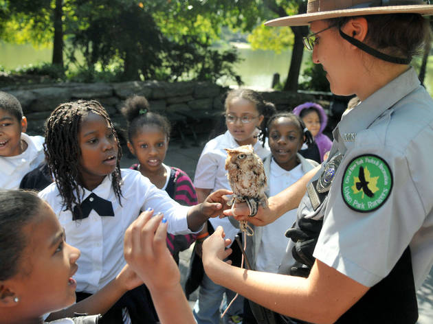 kids in uniforms around owl held by park ranger