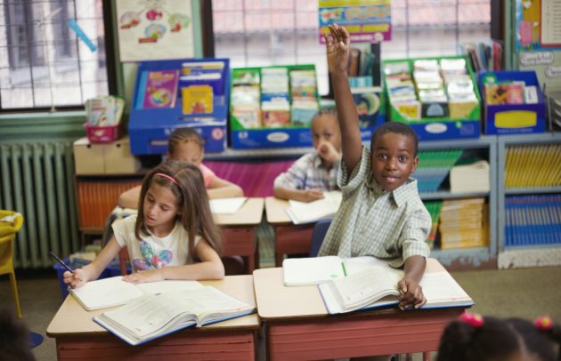 Boy raising hand in classroom
