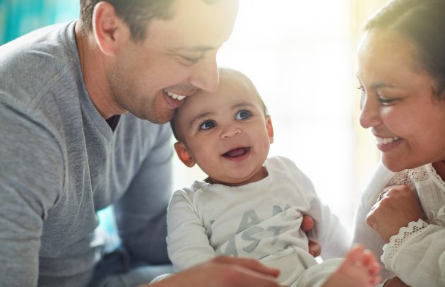 Shot of an adorable baby boy bonding with his father and father at home