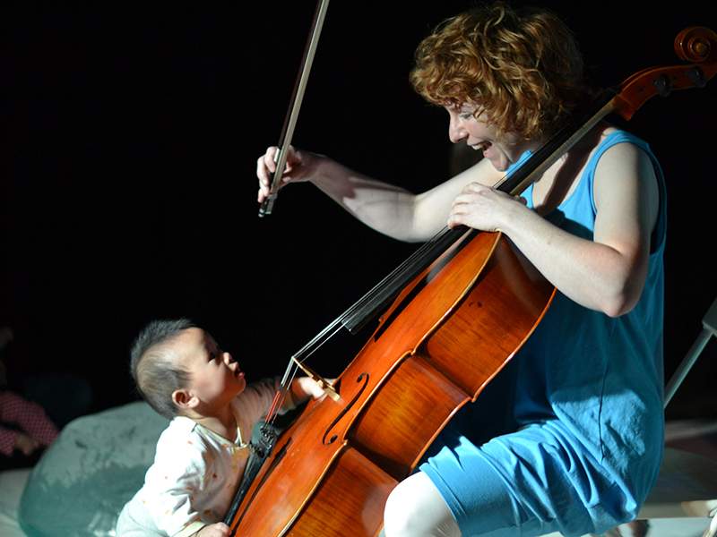 baby touches cello with female cellist