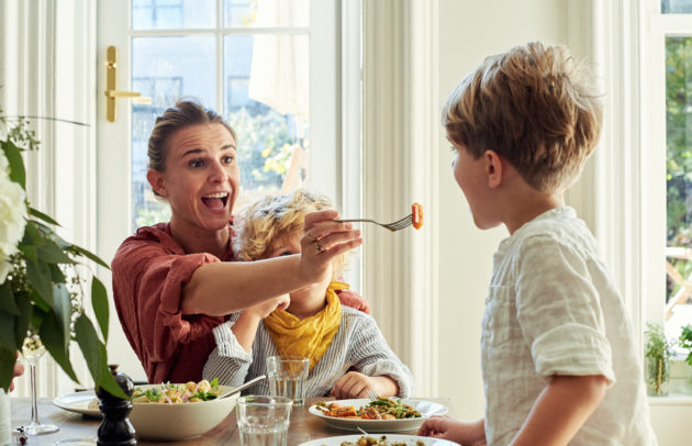 mom feeding her little kid at the table