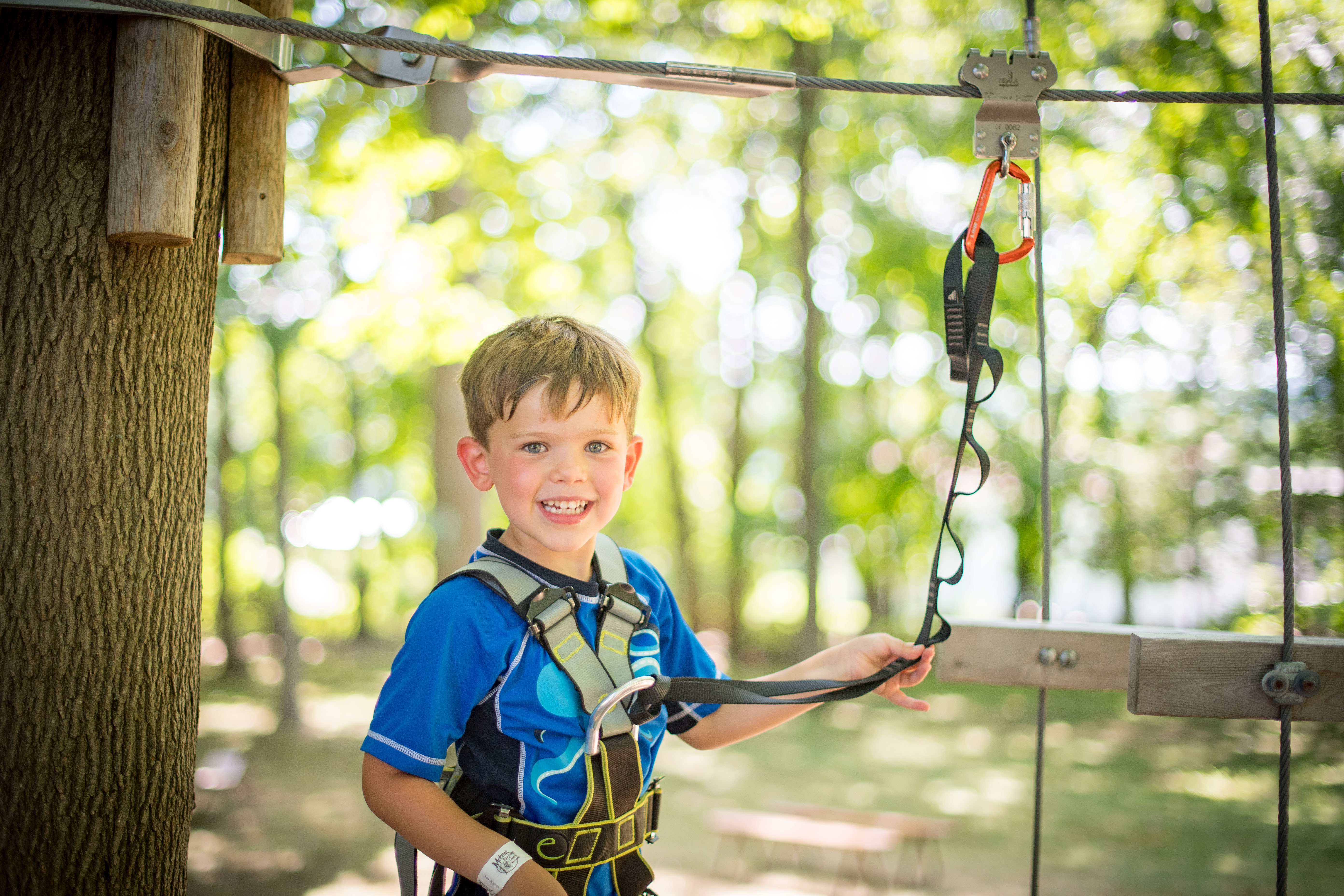little boy at summer camp about to try zip-lining