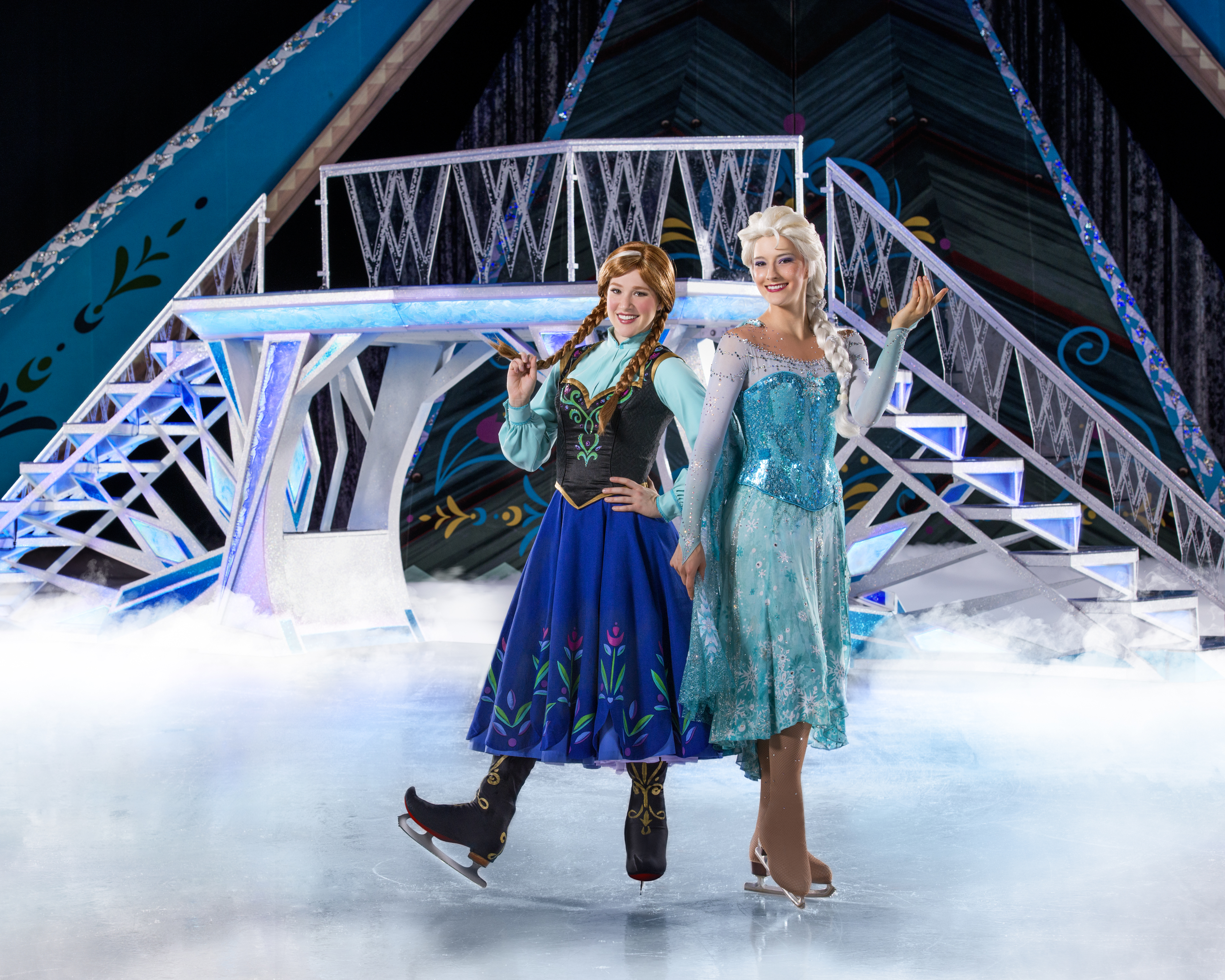 elsa and anna skating on ice during a frozen performance