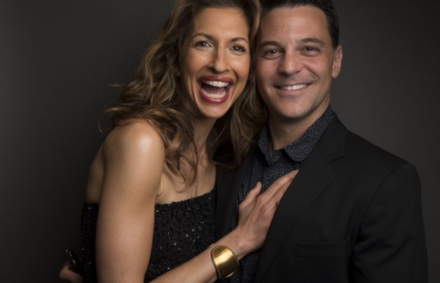 middle aged couple embracing and smiling for posed photo