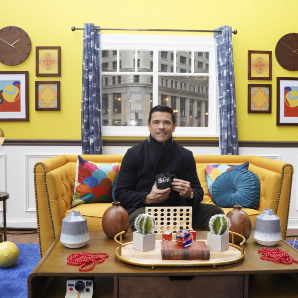 attractive man with dark hair in a styled setting drinking coffee