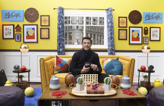 attractive man with dark hair in a styled setting drinking coffee