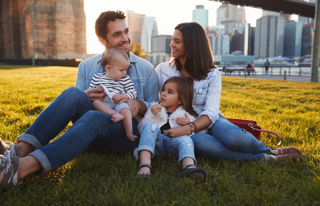 parents with little kids in the city sitting outside in the sun