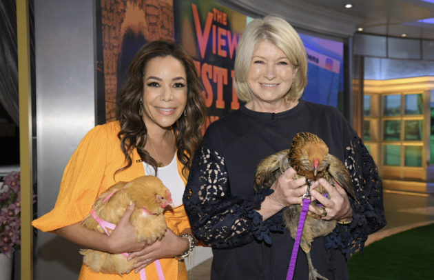 two women holding chickend