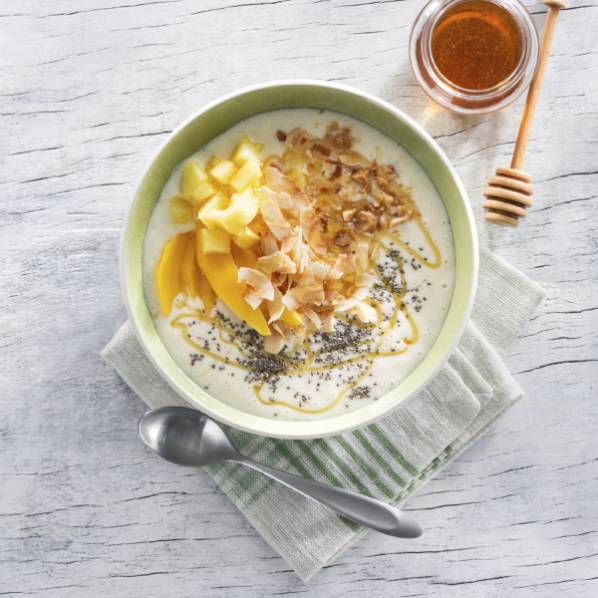 flatlay image of a smoothie bowl with fruit and honey
