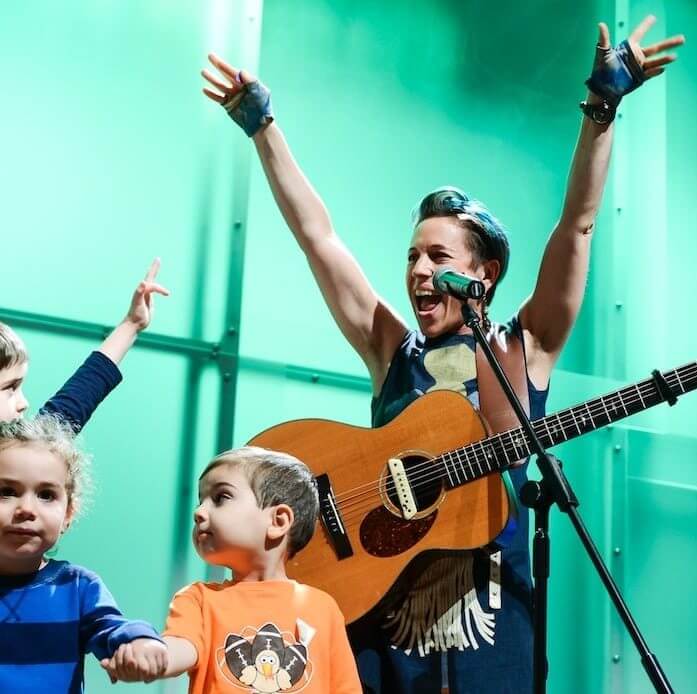 woman and children playing music on stage