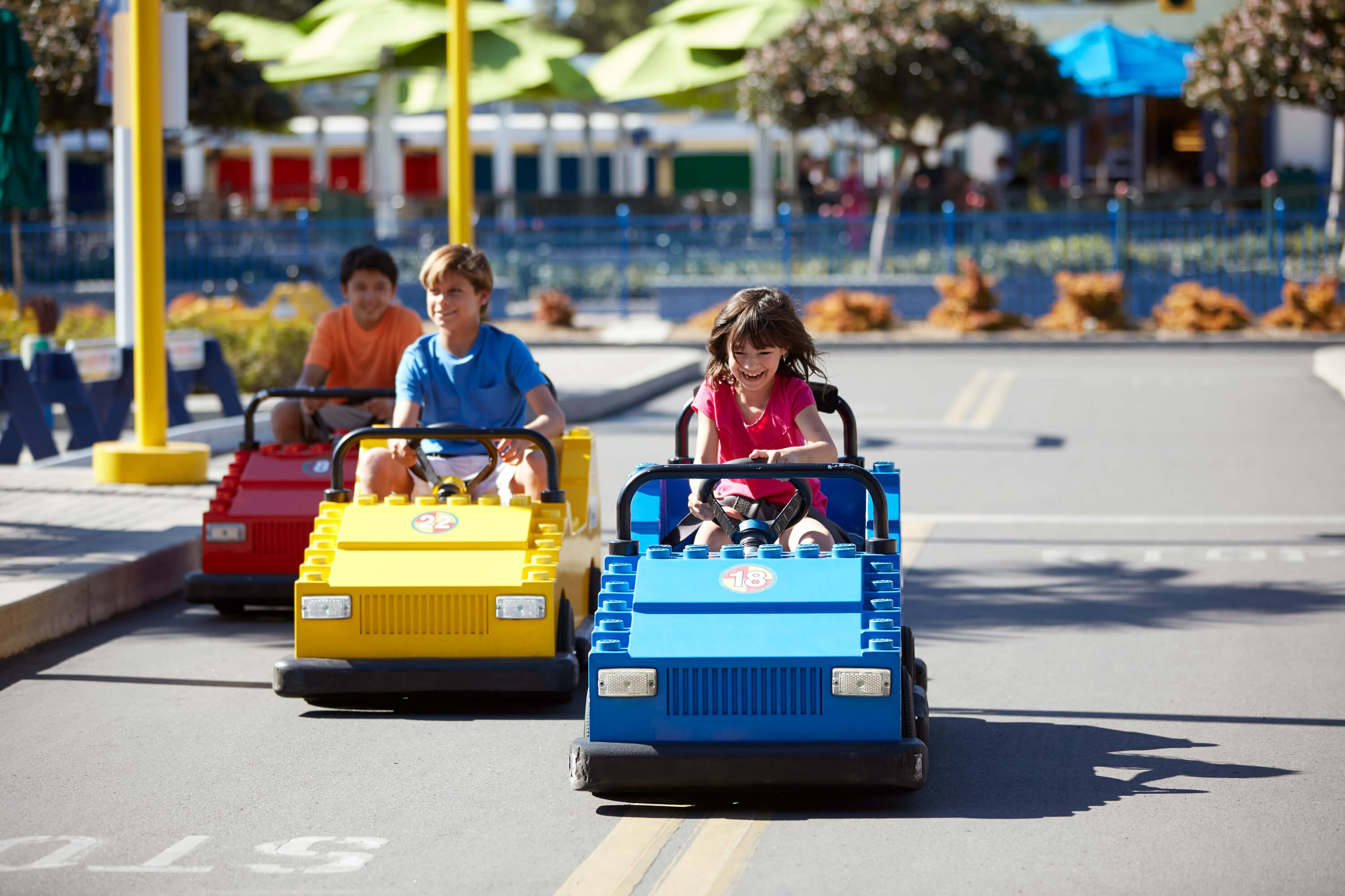 Kids driving LEGO vehicles down a track at LEGOLAND New York