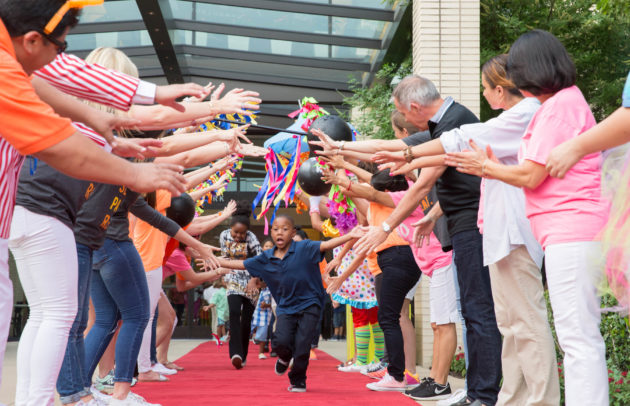 kids running down a red carpet giving high fives