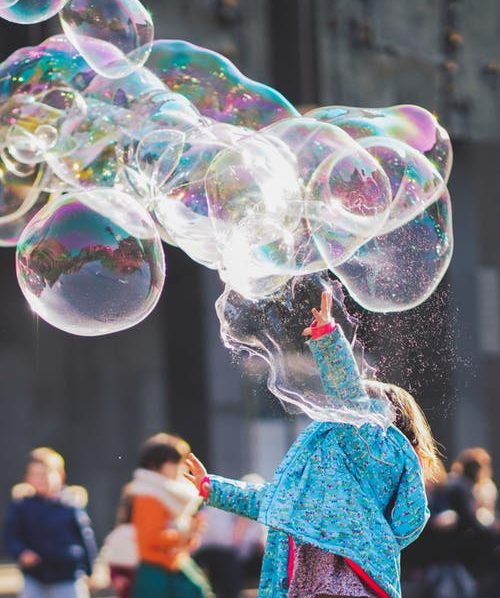 Little girls playing with bubbles on a nice day