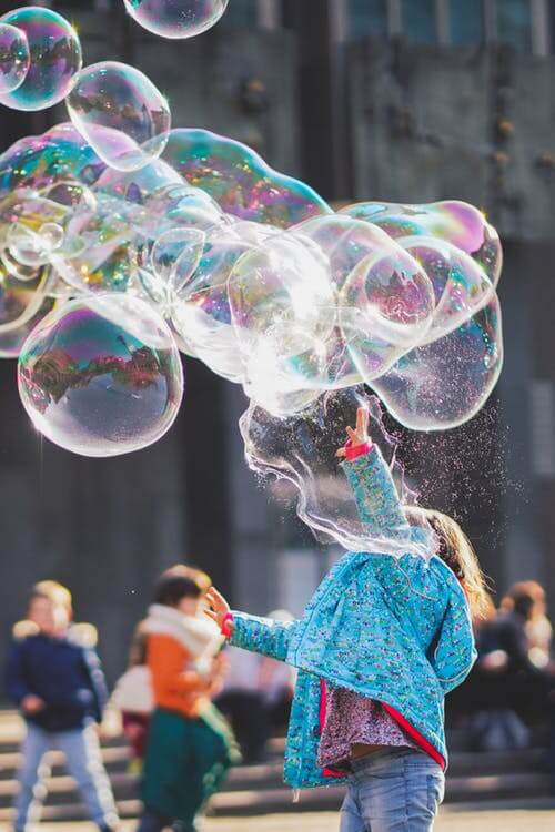 Little girls playing with bubbles on a nice day