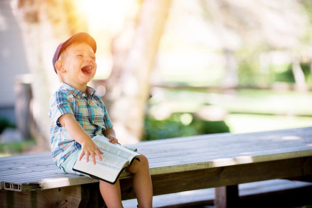 boy laughing on bench