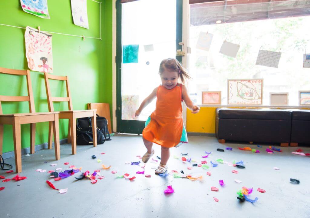 little girl running in her socks and orange dress
