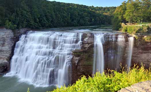 a waterfall amidst green trees 