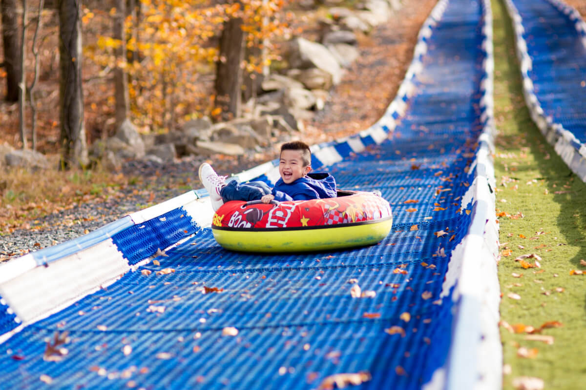 boy in a tube sliding down a hill
