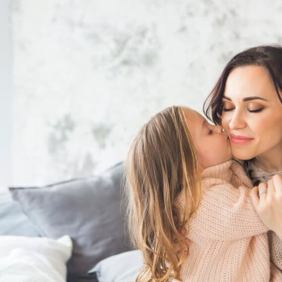 daughter kissing mom on cheek 