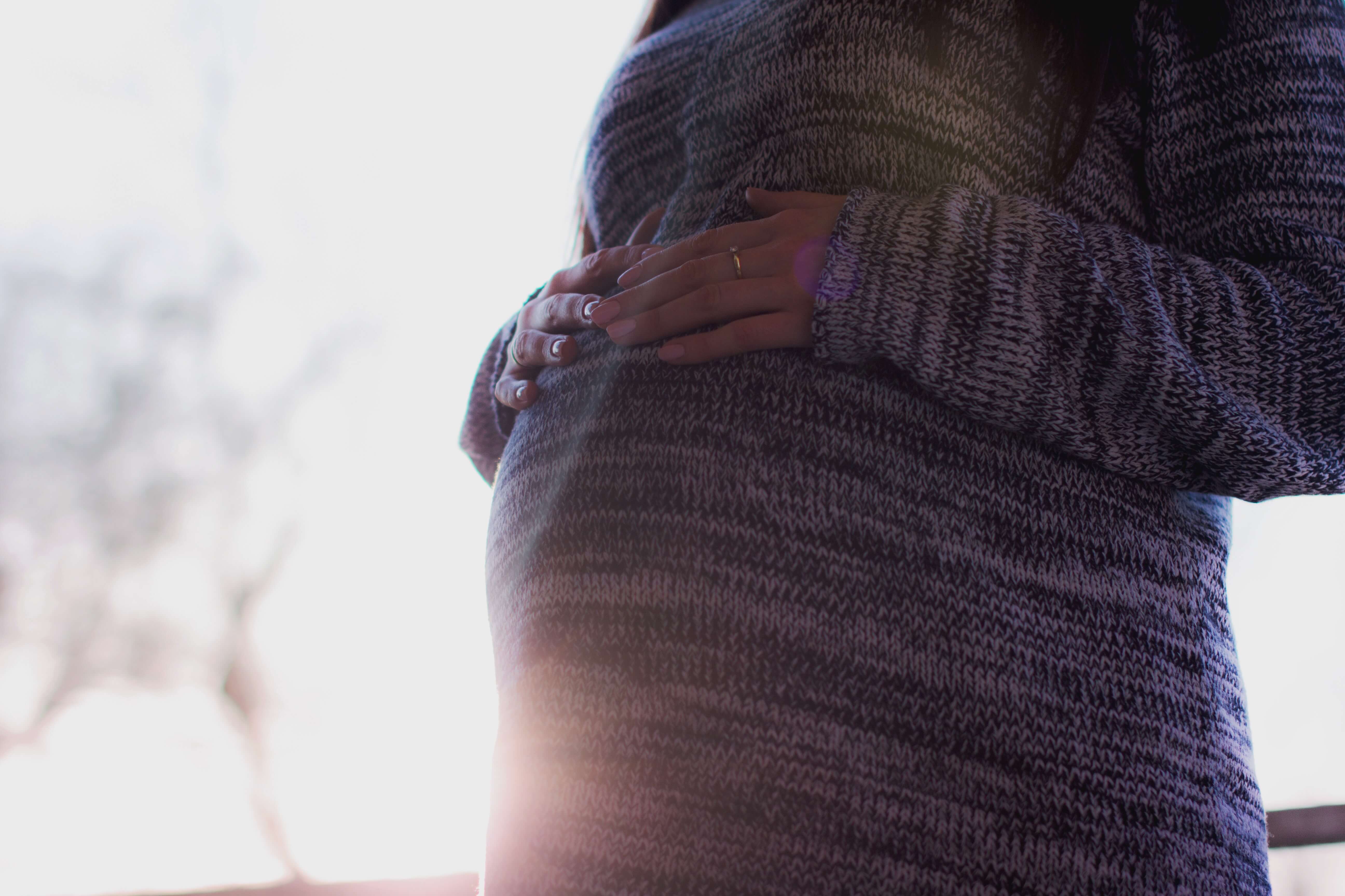pregnant-woman-wearing-marled-gray-sweater-touching-her-54289