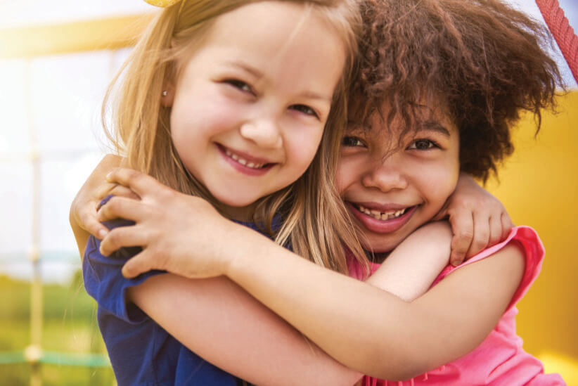 two young girls hugging each other at day camp for kids
