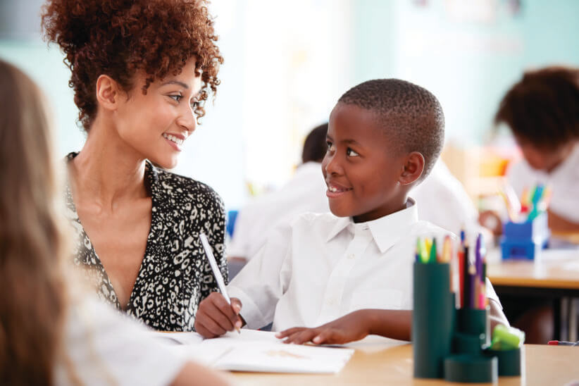 teacher looking at student: charter school for your kids