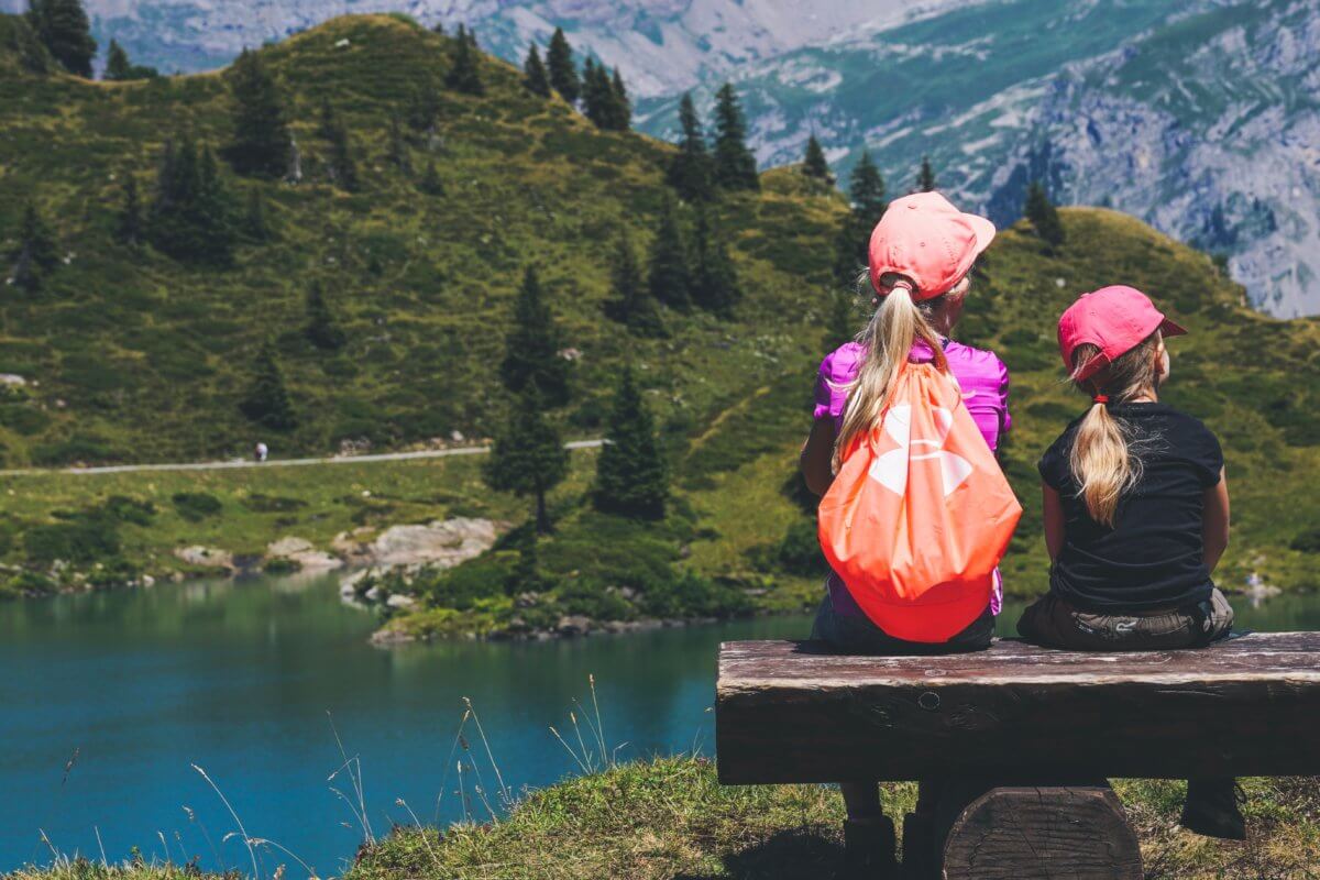 two-girls-sitting-on-bench-looking-at-lake.jpg