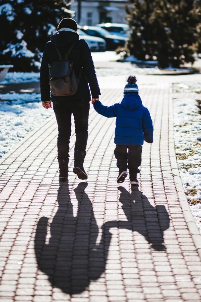 child with parent walking down a stone path