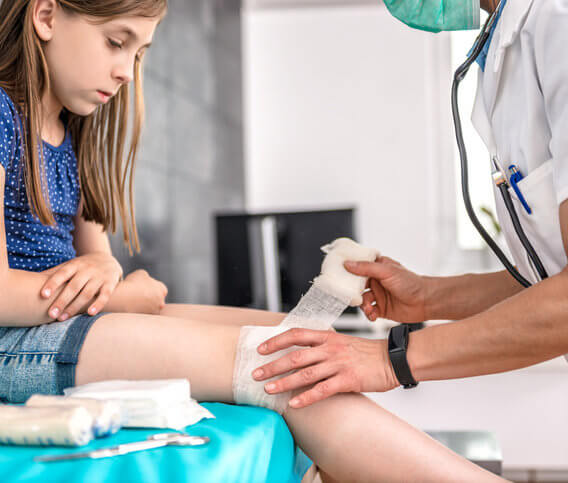 doctor wrapping a child's knee