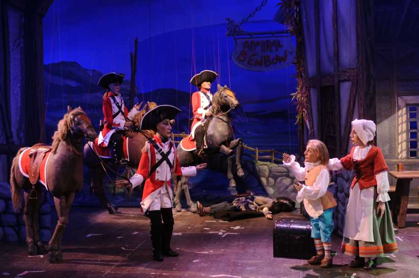  That looks like a scene from a professional marionette or puppet theater production. The setting appears to be a stage play of a classic story, likely Treasure Island, given the prominent "Admiral Benbow" inn sign in the background.