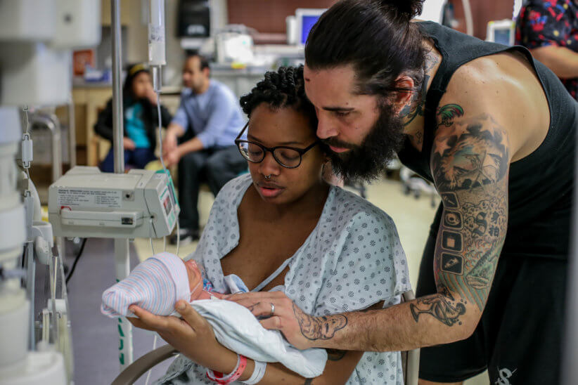 parents holding their newborn child