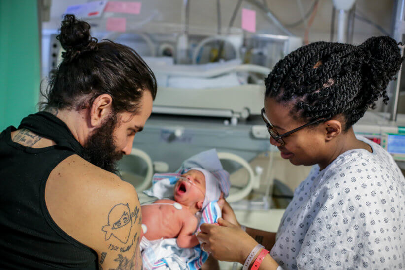 parents holding their newborn child