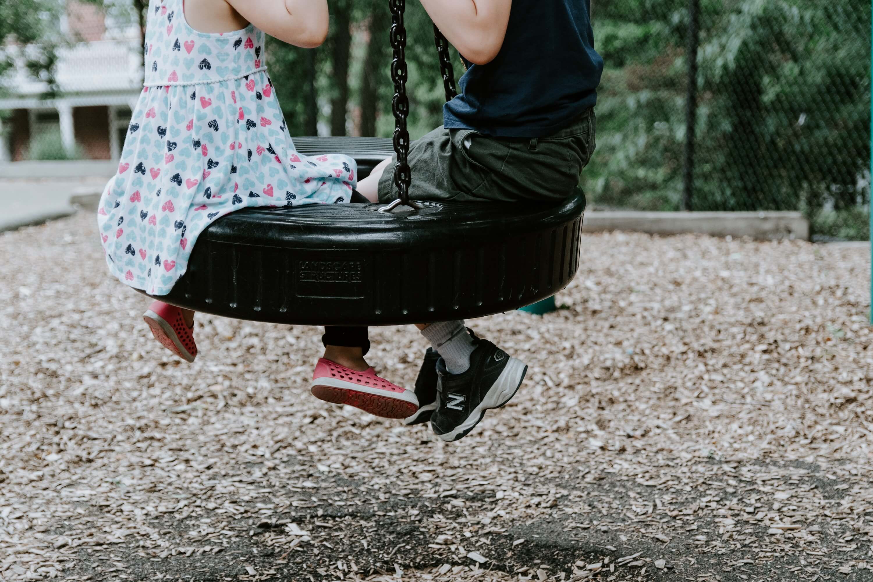 kids sitting in a tire swing