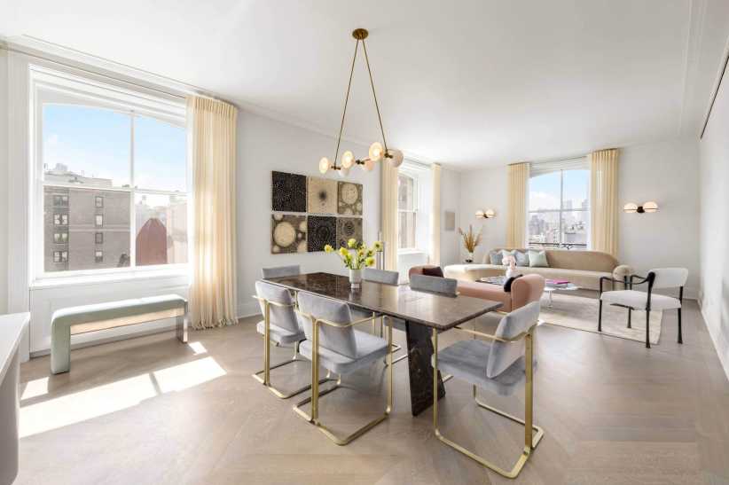 Bright and elegant living-dining space with large windows, pastel furniture, a modern chandelier, and city views outside.